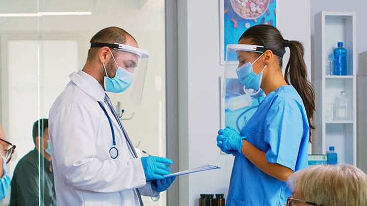 Two medical professionals having a conversation in a healthcare setting.